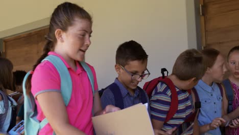 grupo de niños con libros caminando en el pasillo de la escuela