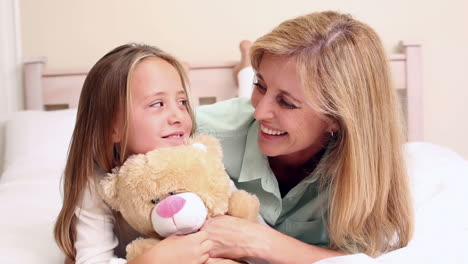 Mother-and-daughter-chatting-on-bed