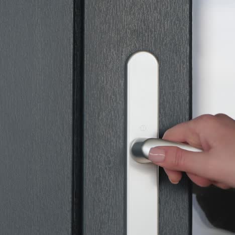 a man in protective latex gloves leaves the house - close-up of the doorknob 1