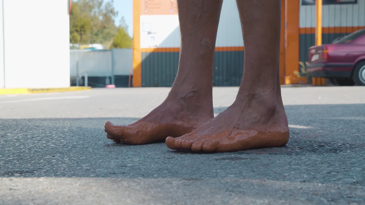 Close-up of a runner's wet feet, while taking a break from a marathon in which he's running barefoot