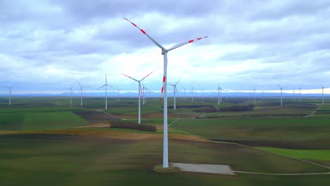 Rotating-Wind-Turbines-With-Greenery-Field-Landscape-In-Countryside