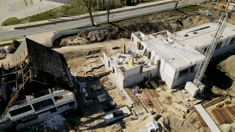 Aerial view showing old rustic restaurant building beside new build building on construction site during summer