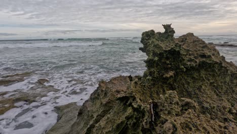 waves crashing against limestone rocks on the shore