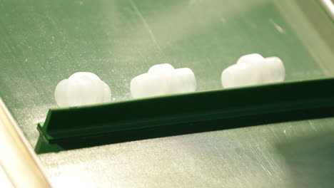 productos de plástico semiacabados sobre cinta transportadora en una fábrica de moldeo por inyección