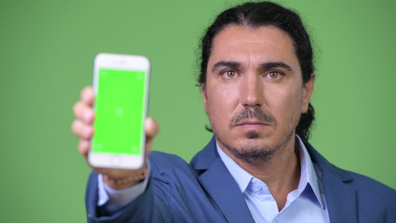 Happy handsome businessman showing phone