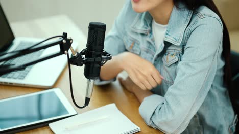 content creator woman host streaming his a podcast on laptop with headphones and microphone interview cheering guest conversation at broadcast studio. blogger motivation recording voice over radio.