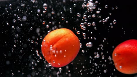 apricots splashing in water