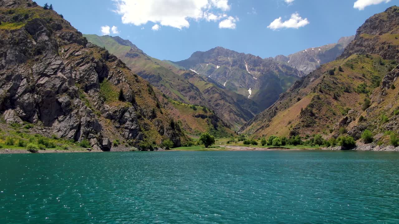 agua prístina hacia el paisaje montañoso en el lago urungach en uzbekistán