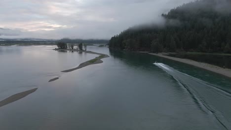 4k drone footage of jet boat moving up a river to go fishing