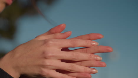 close-up shot of hands gently rubbing together, a subtle gesture of deep contemplation and sadness. the head is partially visible, suggesting a moment of reflection or sorrowful thought