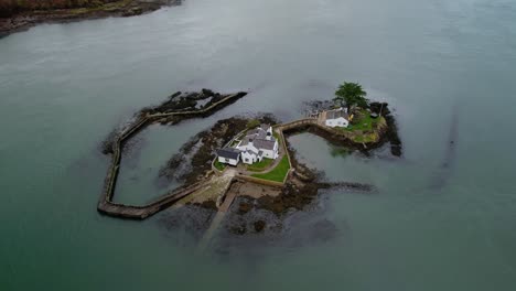 Red-Weir-Island-or-Ynys-Gored-Goch-in-Swellies-Strait-with-Menai-Suspension-Bridge-in-background,-Wales-in-UK