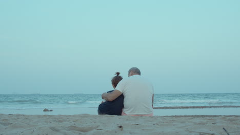 Grandfather-and-grandson-are-sitting-on-the-shore