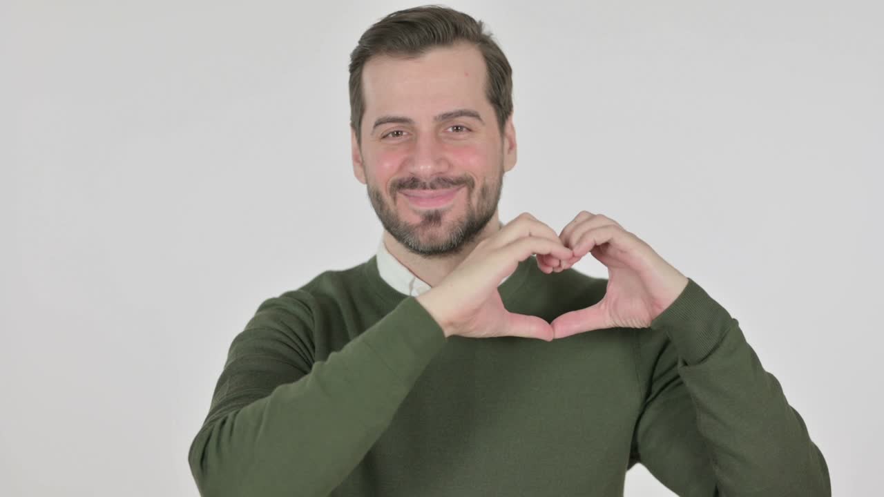 Hombre formando un corazón con las manos, pantalla blanca