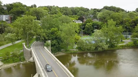 Aerial-view-flying-over-a-bridge-crossing-a-river-on-an-overcast-summer-day-in-Toronto
