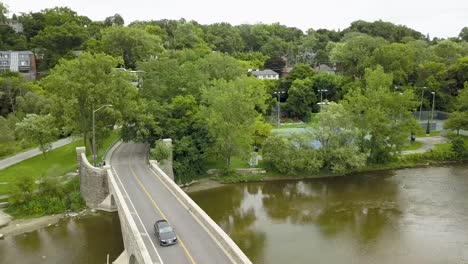 aerial view flying over a bridge crossing a river on an overcast summer day in toronto