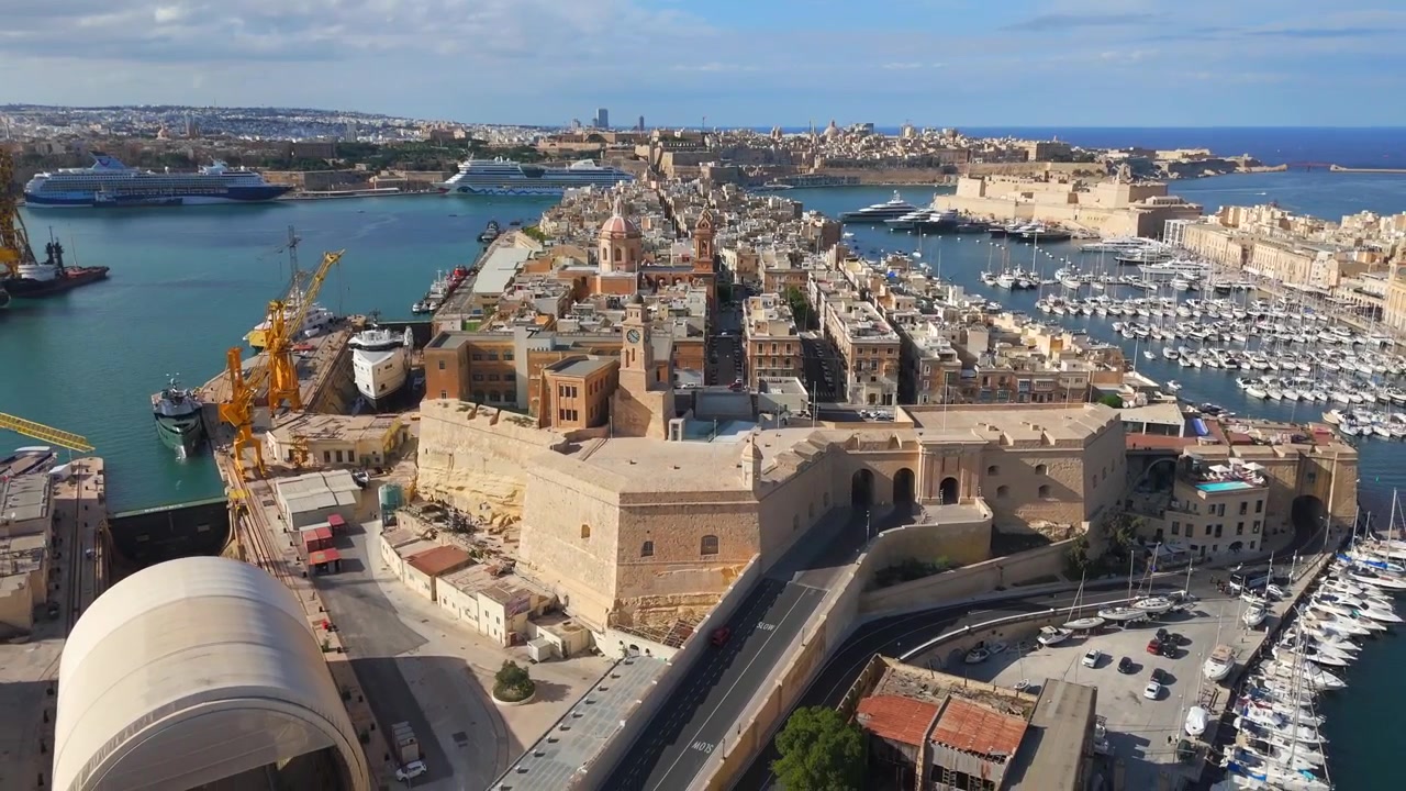 A orla de Birgu brilha sob a luz do sol, emoldurada por fortes centenários e elegantes casas geminadas