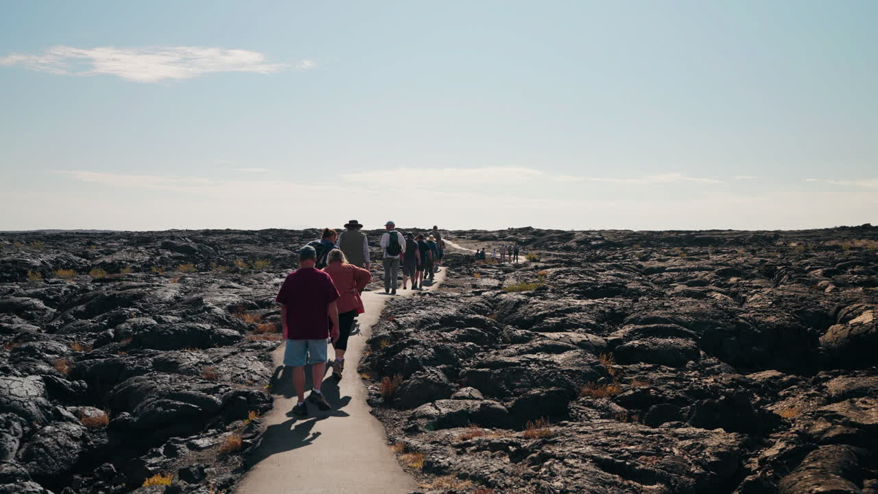 Group of People Hiking Through a Volcanic Lava Field