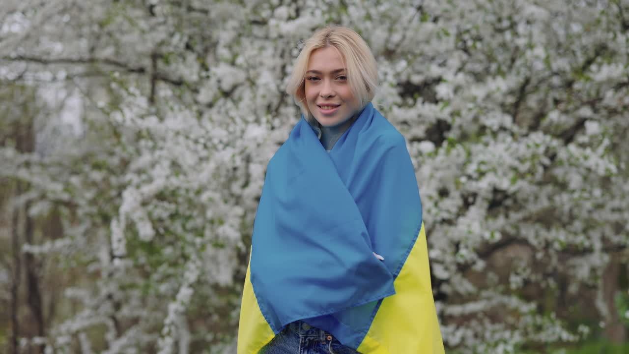 Woman with Ukrainian Flag in Blossom Garden