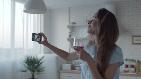 young woman posing for photo with glass of red wine. girl making selfie photo.