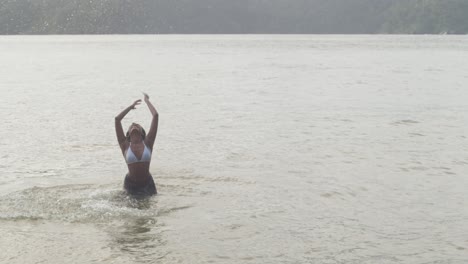 una niña bailando alegremente en el cálido mar caribe
