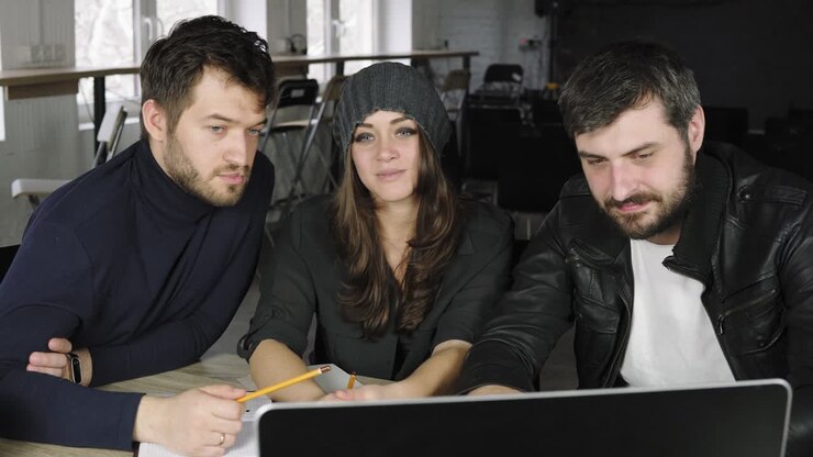 Team of young professionals having a conference call in a creative office. Business discussion. Coffee cups on the table. Shot in 4k