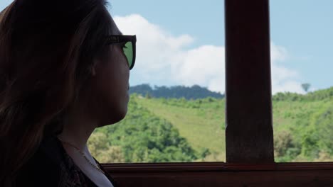 mujer asiática en un viaje en barco con un fondo verde exuberante, cámara lenta