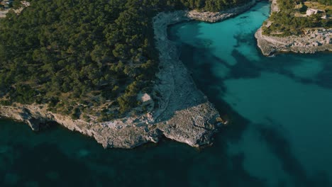 agua de mar azul turquesa clara, barco de vela yate en una bahía natural remota, isla de palma de mallorca