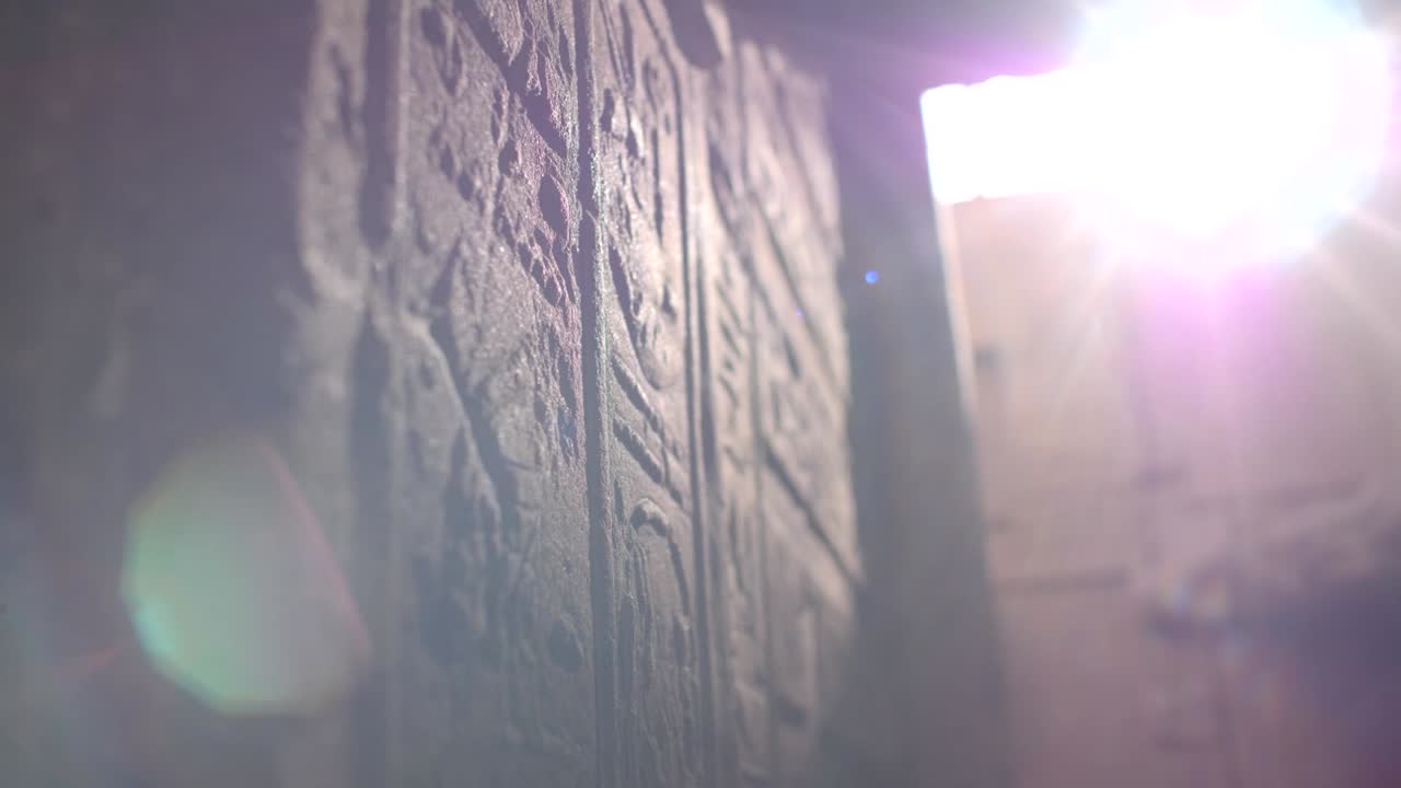 Close details of hieroglyphs litten by sunlight on the walls inside the temple of Philae, Aswan, Egypt.