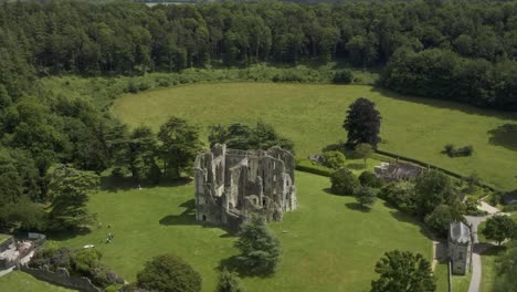 old wardour castle ruins surrounded by bright green fields and forest