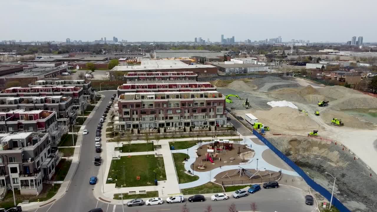disparo de drones dando vueltas alrededor del vecindario de toronto con un parque infantil cerca de un sitio de construcción