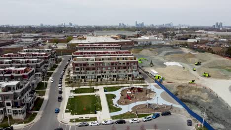 drone shot circling around toronto neighborhood with a playground near a construction site