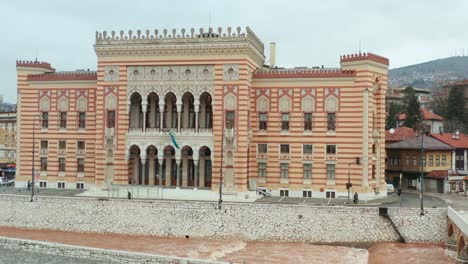 aerial rising shot of the city hall of sarajevo, bosnia herzegovina on an overcast day