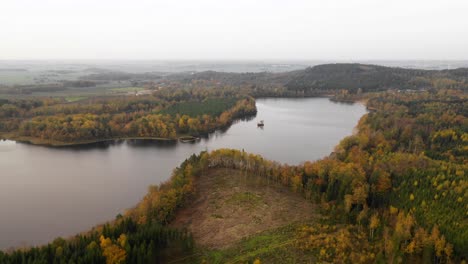 Aerial-view-of-lake-in-forest-with-autumn-colors