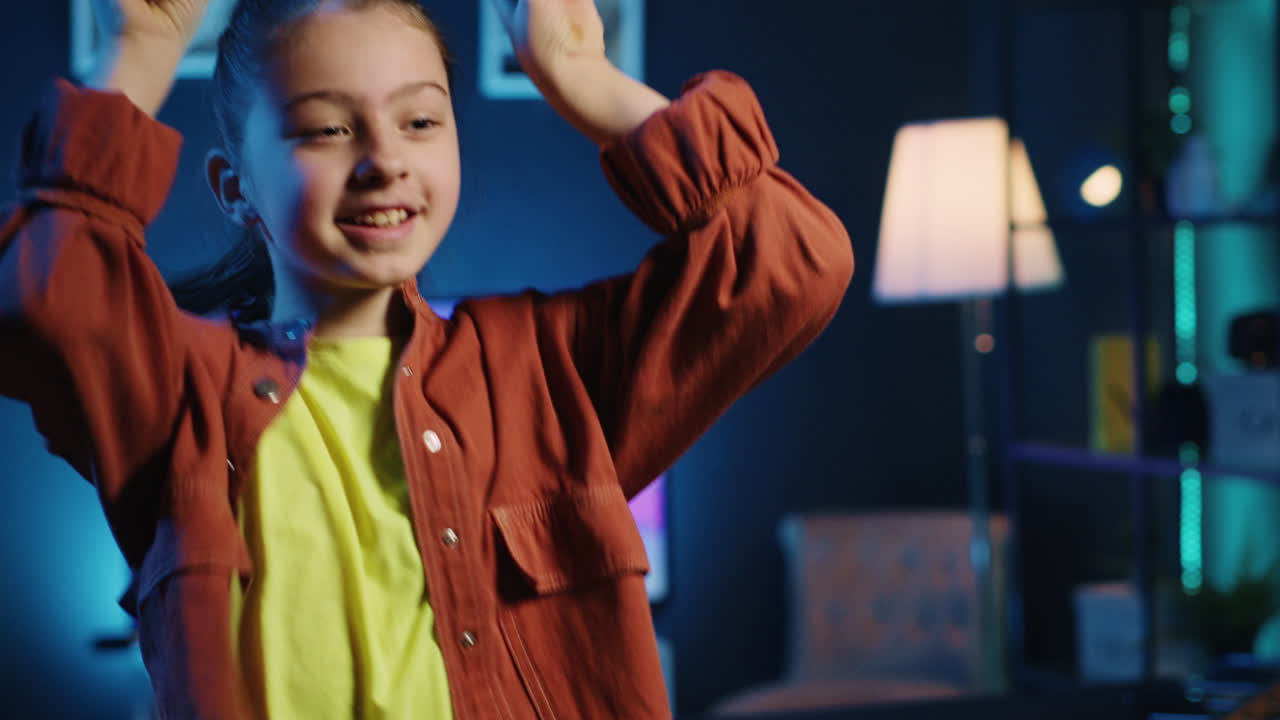 Cute smiling kid filming dance tutorial for other children watching her ...