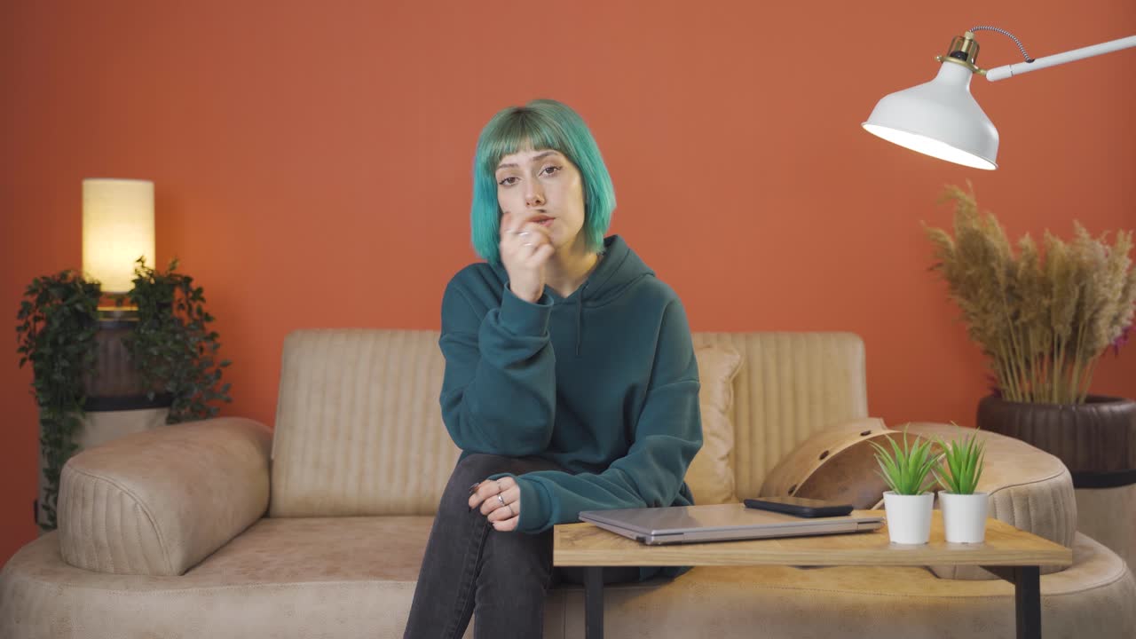 una mujer joven mirando pensativa a la cámara.