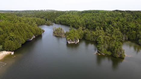 aerial shot flying up over a sunny lake with a beach in guelph