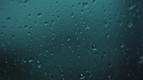 Gotas-De-Agua-De-Lluvia-Cayendo-Sobre-El-Cristal-De-La-Ventana-Azul