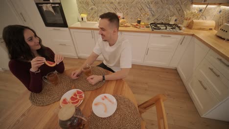 una pareja enamorada haciendo un sándwich en la cocina de la sala de estar