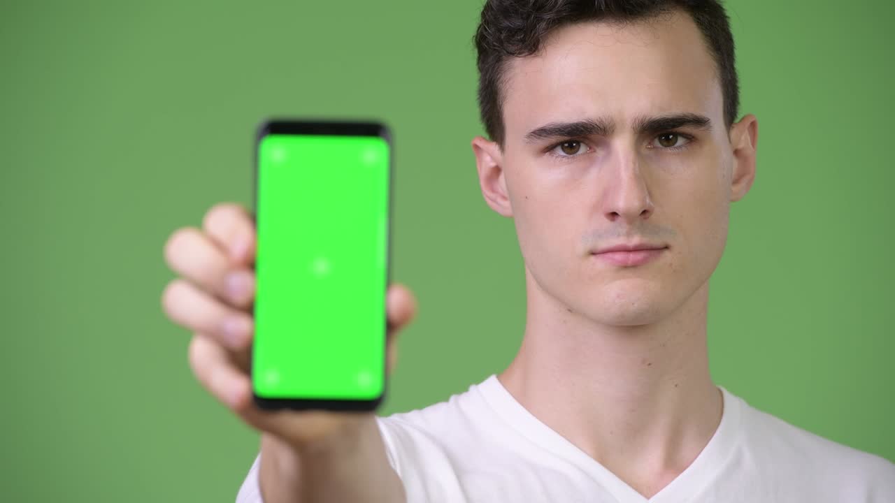 Young handsome man showing phone