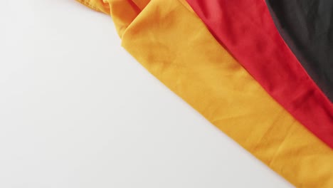 Video-of-creased-flag-of-germany-lying-on-white-background