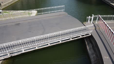 a mobile bridge over the saint-martin canal is opening to let the boats to pass through and out of the seine river in paris