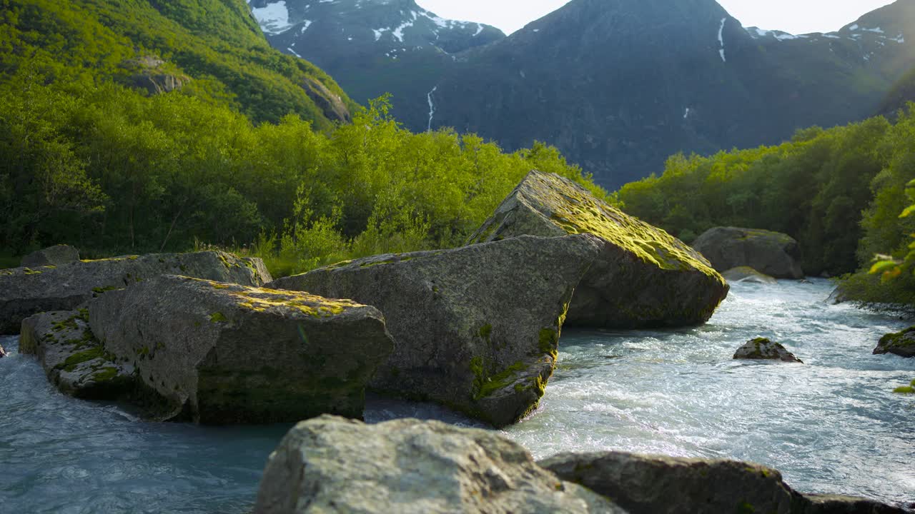 Briksdalsbreen mountain river Volefossen, Norway. Glacier water flowing through lush nature forest.