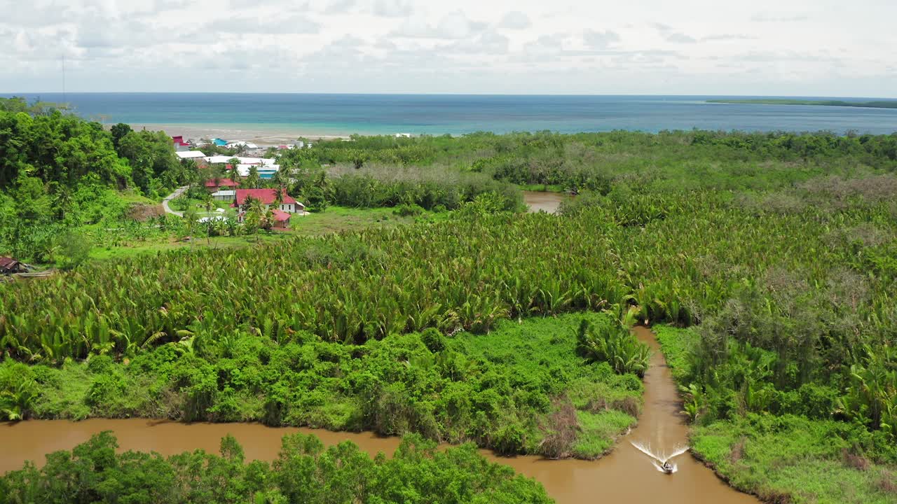 tiro de grúa aérea de barco en el río del pueblo en la selva verde de indonesia