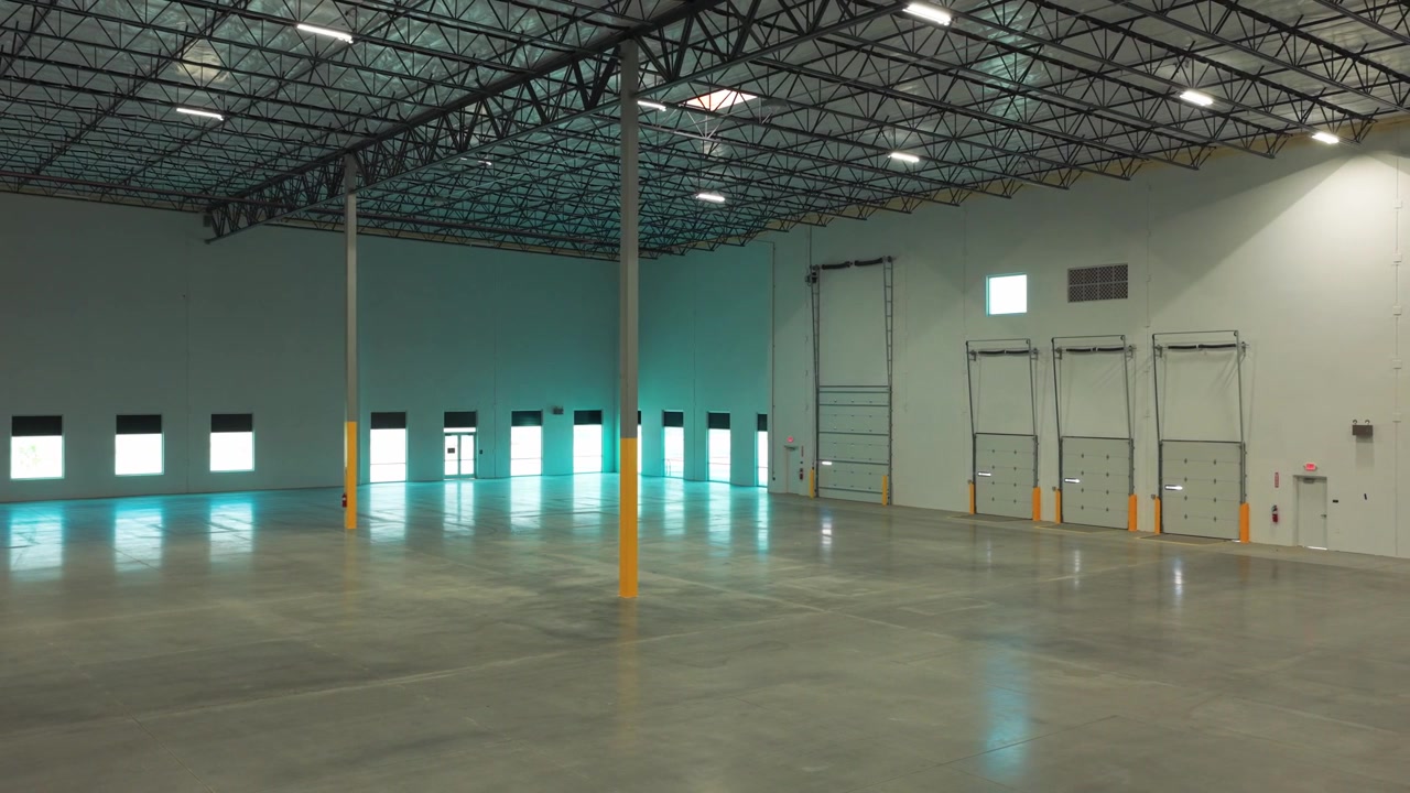Wide aerial dolly shot of the speed bay inside an industrial warehouse in Lancaster, California. 4K