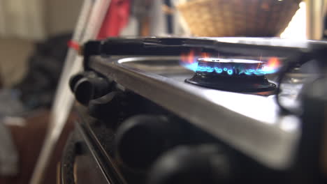 man sets tea pot onto stainless stove top