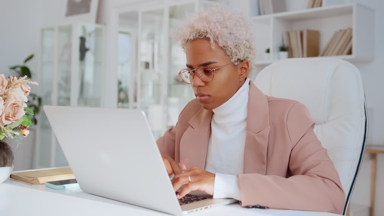 joven mujer de negocios afroamericana escribiendo en una computadora portátil trabajando en su propia compañía