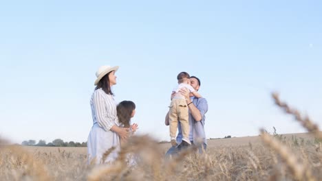 a happy family enjoys a day in a wheat field