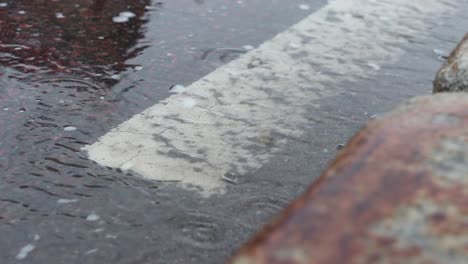 Rain-water-running-down-gutter-on-the-side-of-the-road