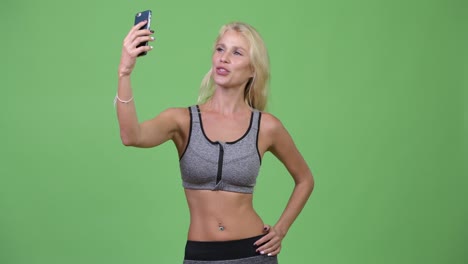 young beautiful woman vlogging with phone ready for gym