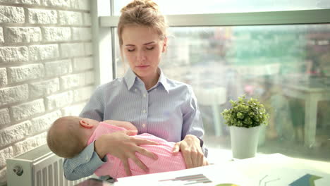 Mujer-Cansada-Bosteza-Con-Un-Niño-Dormido-En-Las-Manos.-Mamá-Soñolienta-Con-Niño-En-El-Lugar-De-Trabajo